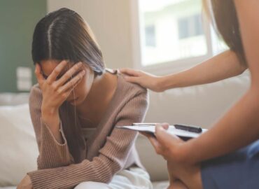 A young woman being consoled by a therapist